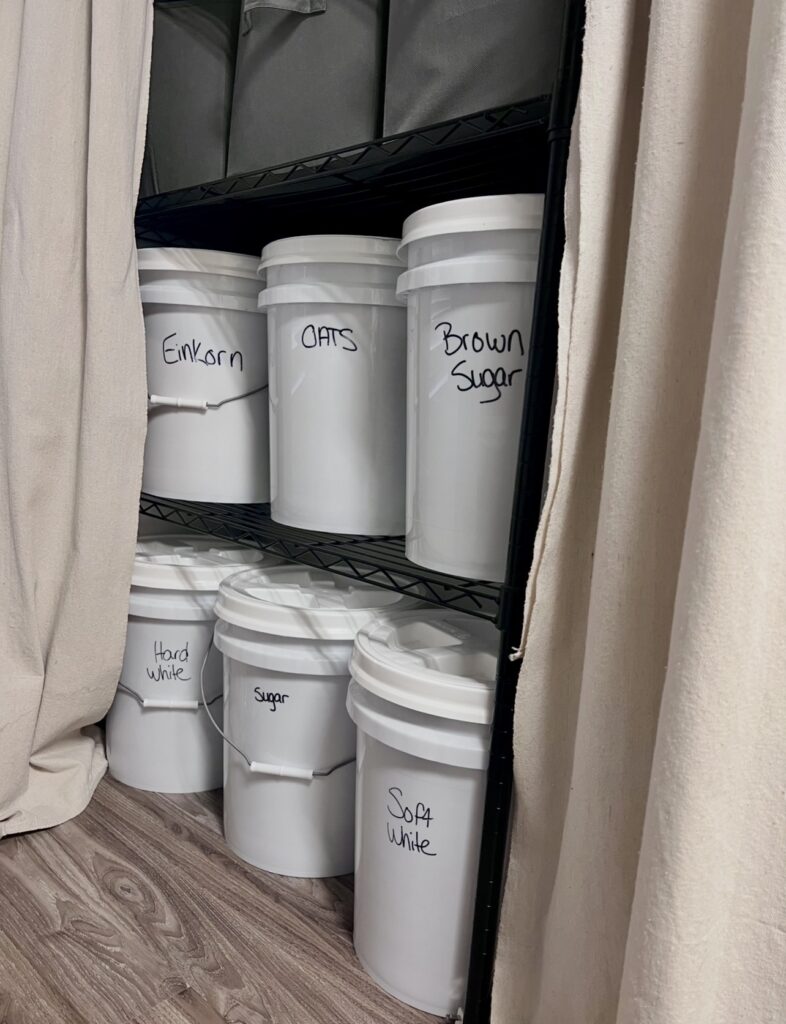 Bulk food storage in sealed 5-gallon buckets for long-term emergency pantry use.