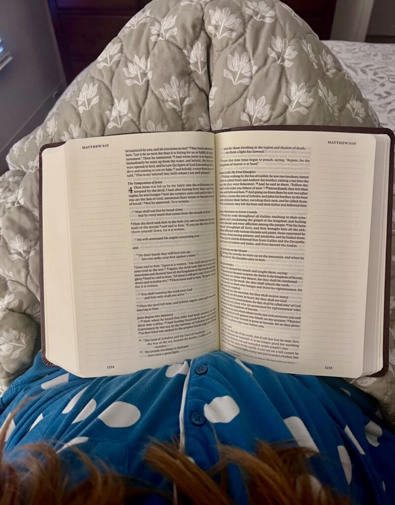 Stay-at-home mom reading a book in bed as part of a simple evening routine for a peaceful morning.